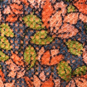 Peut inclure: Gros plan sur un tissu avec un motif tiss&eacute; textur&eacute;. Le tissu est un m&eacute;lange d'orange, de rose, de vert et de noir.