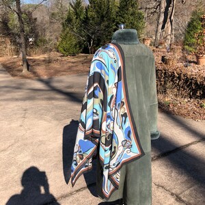 May include: A green suede coat with a fur collar and a blue, brown, and white patterned scarf draped over it.