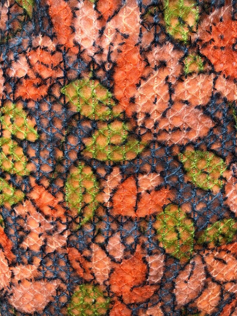 Peut inclure: Gros plan sur un tissu avec un motif tiss&eacute; textur&eacute;. Le tissu est un m&eacute;lange d'orange, de rose, de vert et de noir.