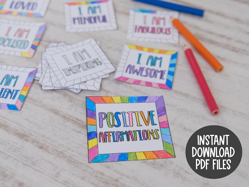 Op de afbeelding: Een set printbare positieve affirmatiecards met een regenboogrand. De kaarten bevatten zinnen als "Ik ben geliefd", "Ik ben aandachtig", "Ik ben inspirerend", "Ik ben geweldig" en "Ik ben fantastisch". De kaarten zijn klaar om te worden afgedrukt en ingekleurd.