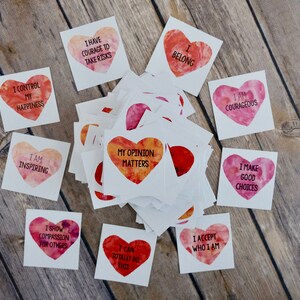May include: A set of affirmation cards with watercolor hearts featuring positive messages like "I control my happiness", "I am inspiring", and "My opinion matters".