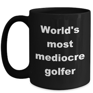 May include: Black coffee mug with white text that reads "World's most mediocre golfer".
