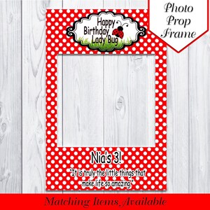 Puede incluir: Marco de fotomatón rojo y blanco con lunares. La parte superior del marco dice "Happy Birthday Lady Bug" con una ilustración de mariquita. La parte inferior del marco dice "Nia's 3!" y "It is truly the little things that make life so amazing."