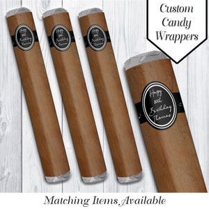May include: Four brown cigar-shaped candy wrappers with black and white labels that say "Happy 80th Birthday Thamas". The wrappers are on a white wood background. Custom Candy Wrappers.