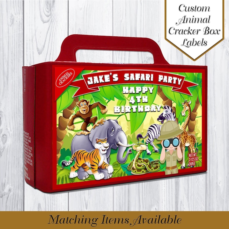 May include: Red and green animal cracker box with a handle. The box has a jungle theme with a monkey, elephant, tiger, giraffe, zebra, and snake. The text on the box says "JAKE'S SAFARI PARTY HAPPY 4TH BIRTHDAY".