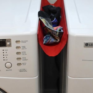 May include: A white ceramic mug with a black handle and the text "But First, Coffee" in a bold, black font. The mug is filled with a dark liquid, likely coffee, and sits on a light-colored surface.