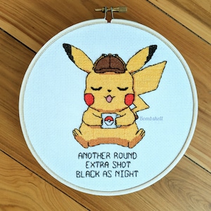 May include: A yellow Pikachu wearing a detective hat and holding a coffee mug with a Pokeball on it. The text below reads "Another round extra shot black as night".