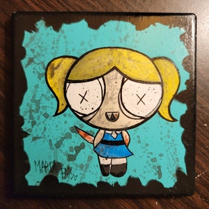 Pode incluir: Uma tela pintada à mão com um personagem de desenho animado com cabelo loiro, olhos azuis e um vestido azul. O personagem tem uma faca ensanguentada na mão e uma expressão ameaçadora. O fundo é azul turquesa com respingos pretos.