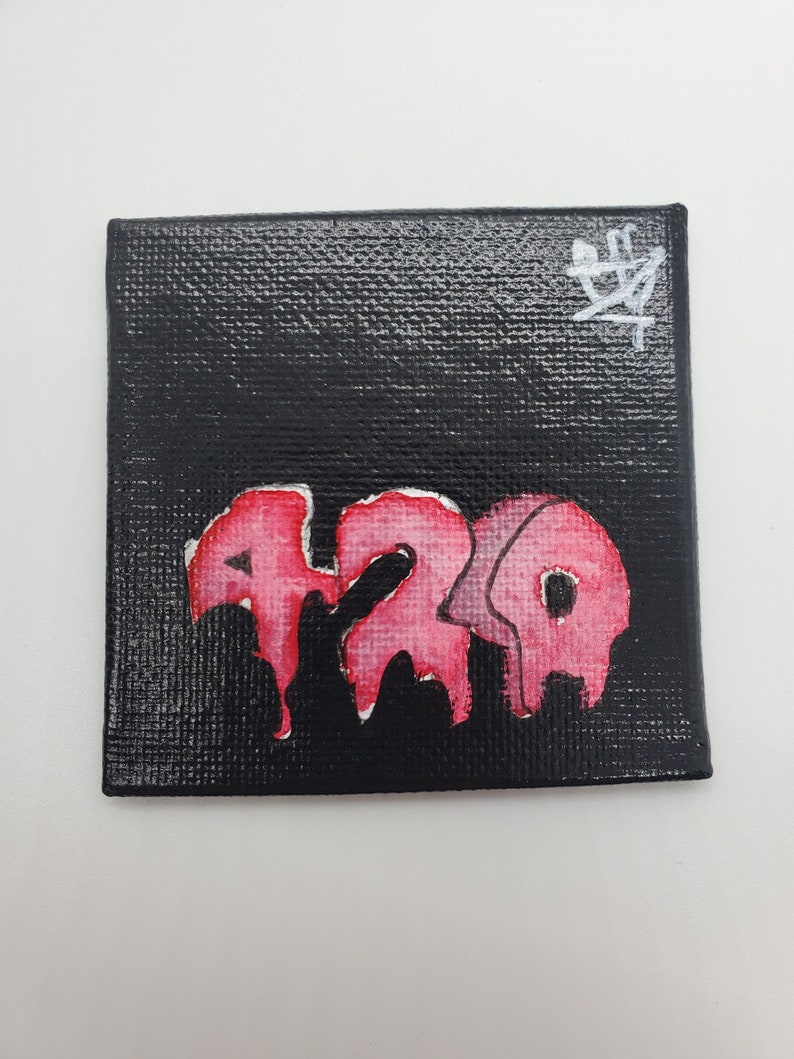 May include: A small black canvas painting with a pink and white dripping paint design that says "420" on it. The painting is signed with a white symbol in the top right corner.