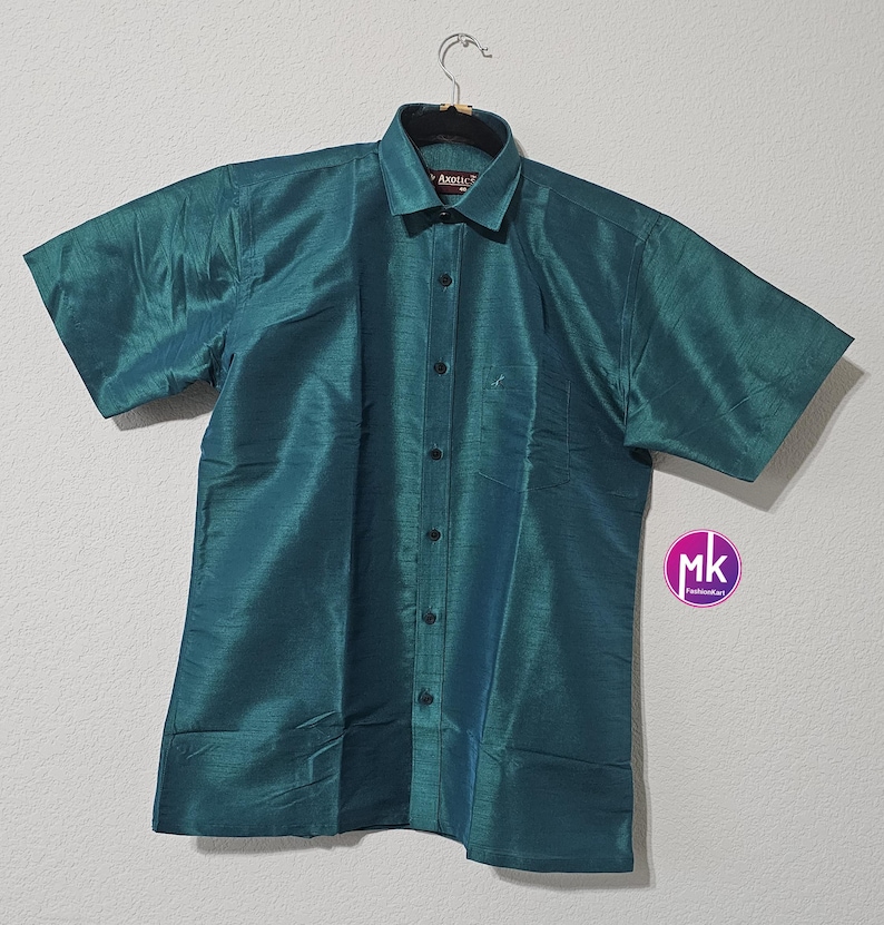 May include: A teal blue short-sleeved button-down shirt with a collar. The shirt has a subtle sheen and is made of a silky material.