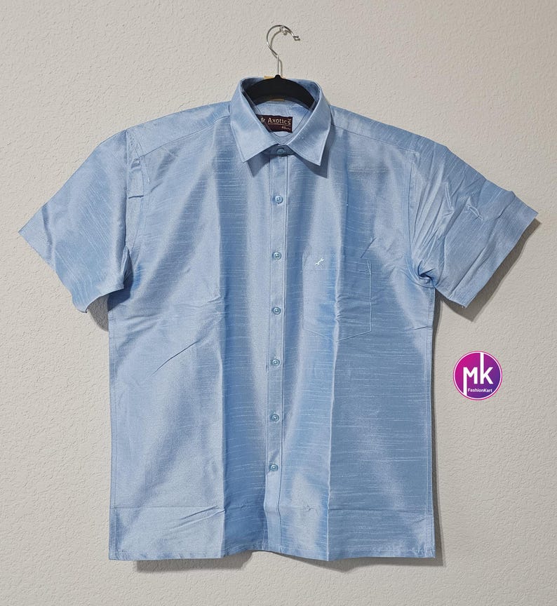 May include: A light blue short-sleeved button-down shirt with a pocket on the left side. The shirt is made of a silky material and has a subtle sheen.