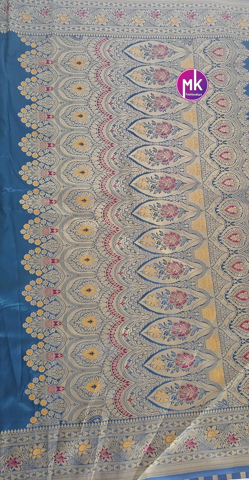Puede incluir: Una tela azul y dorada con un patr&oacute;n repetitivo de dise&ntilde;os florales. La tela tiene un borde con un dise&ntilde;o m&aacute;s intrincado.