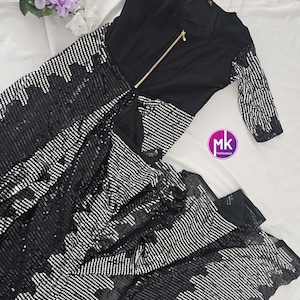 May include: A black sequined dress with a zipper down the front and silver sequins. The dress has long sleeves and a fitted bodice. The dress is made of a soft, comfortable fabric and is perfect for a night out.