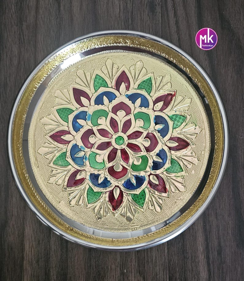 May include: A round, gold-colored metal serving tray with a decorative, multi-colored floral design in the center. The tray has a silver rim.