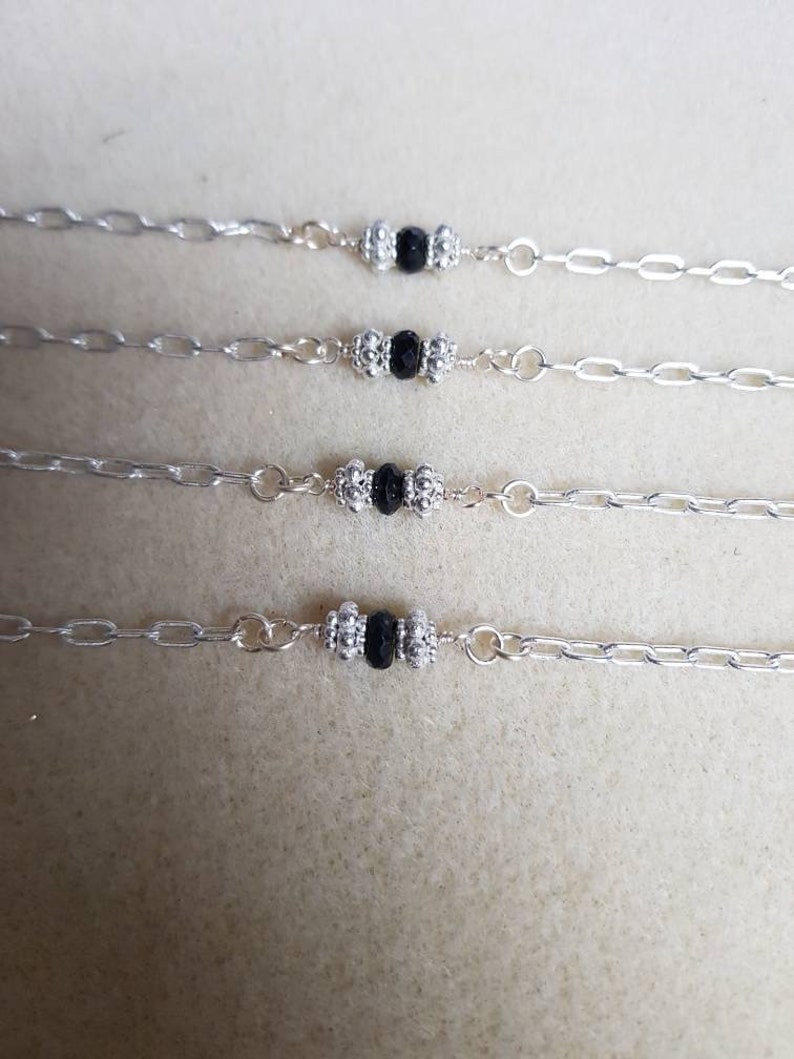 Black faceted spinel silver chain bracelet with 925 sterling silver spacer beads.