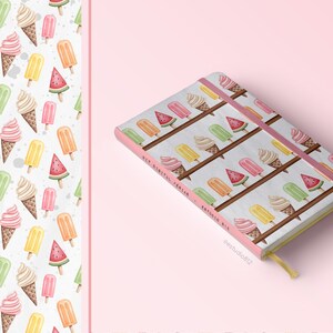 Op de afbeelding: Een roze notitieboek met een witte omslag met een herhalend patroon van ijshoorns, ijslolly's en watermeloenplakjes. Het notitieboek heeft een roze elastiek en de tekst "Eat Dessert, Enjoy Life" op de omslag.