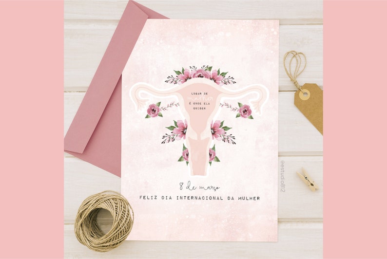 May include: A pink and white card with a stylized illustration of a uterus with flowers. The text on the card reads "Lugar de mulher &eacute; onde ela quiser" and "8 de mar&ccedil;o Feliz Dia Internacional da Mulher".