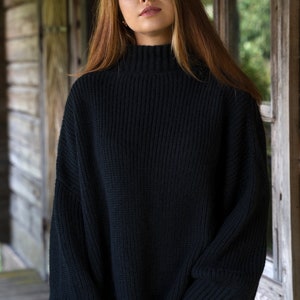 K&ouml;nnte beinhalten: Ein schwarzer Rollkragenpullover mit gerippter Struktur. Der Pullover hat lange &Auml;rmel und eine lockere Passform.