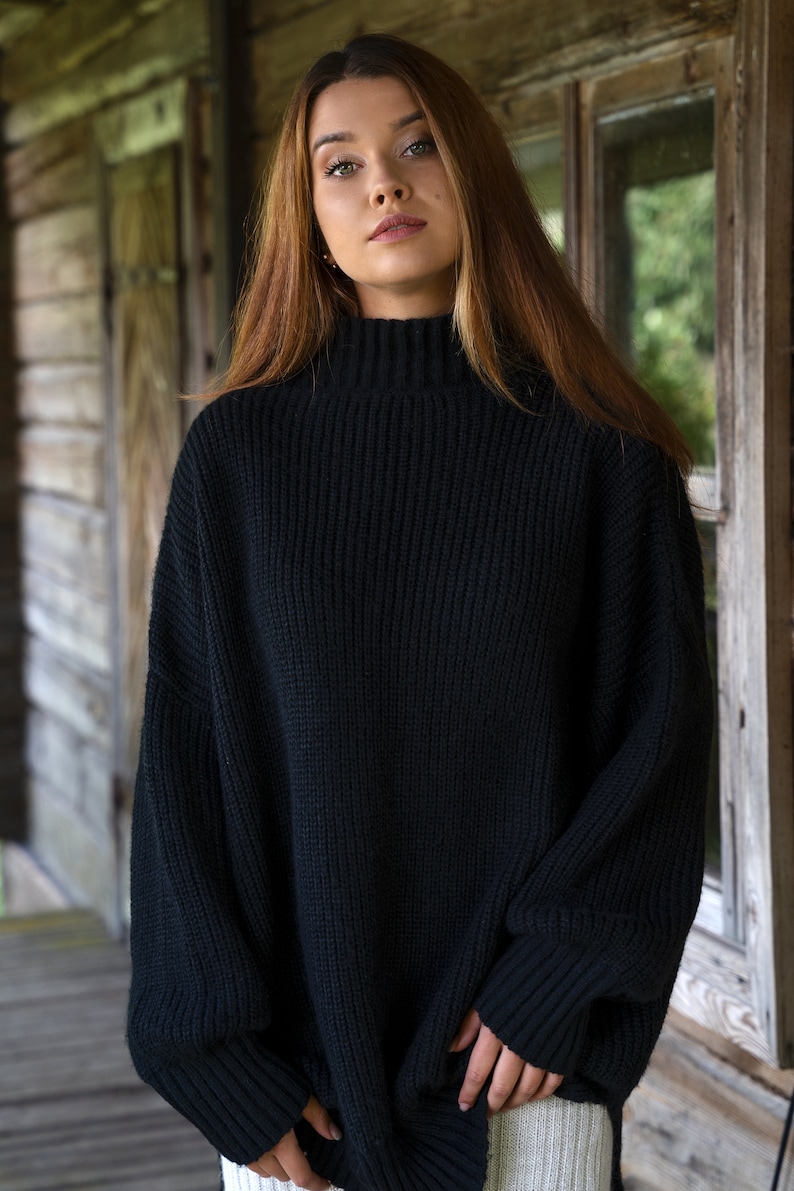 K&ouml;nnte beinhalten: Ein schwarzer Rollkragenpullover mit gerippter Struktur. Der Pullover hat lange &Auml;rmel und eine lockere Passform.