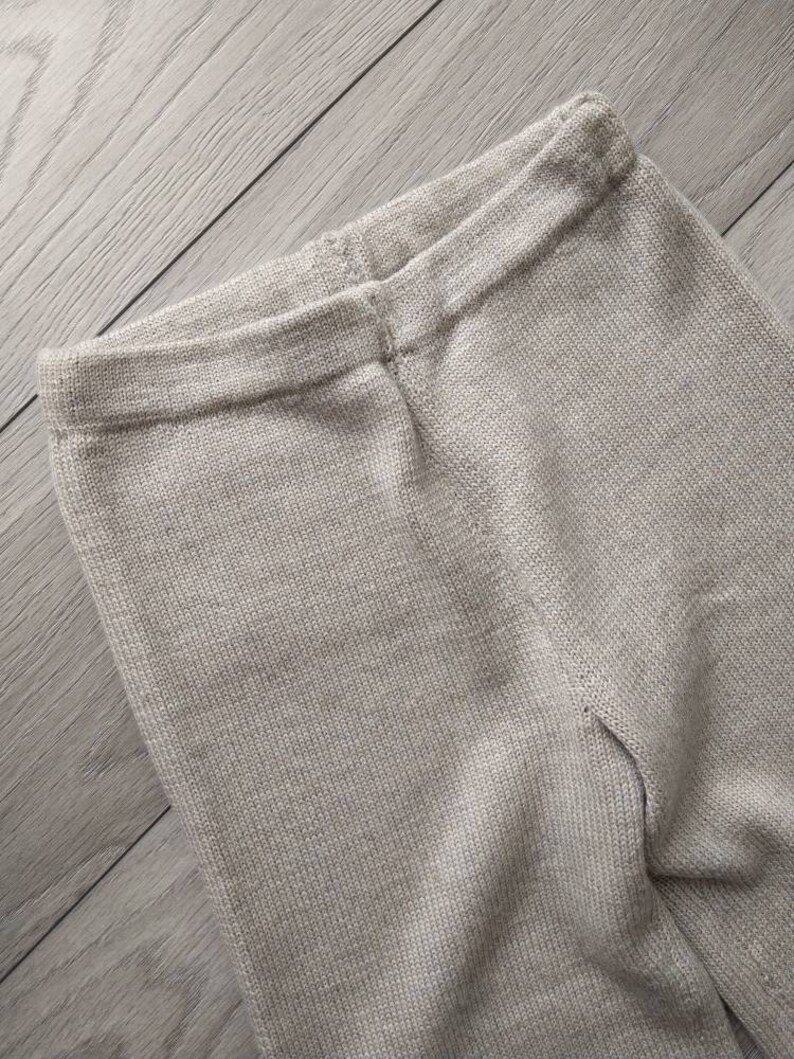 May include: A pair of beige knitted leggings with a ribbed texture.
