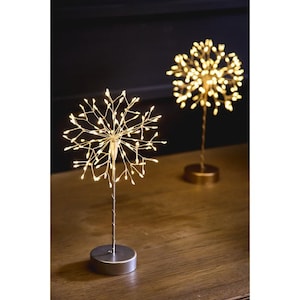May include: Two decorative LED light sculptures. One has a silver base with a wire frame of small lights. The other has a gold base. Both emit a warm, yellow glow, ideal for ambient lighting.