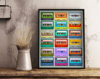 May include: A framed print featuring a grid of colorful cassette tapes. Each tape has a different color and design, with labels and details visible. The artwork is displayed on a wooden surface, with a metal pitcher and dried plants in the foreground.