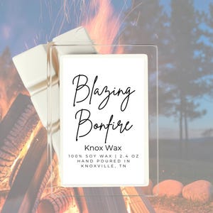 May include: A rectangular white soy wax melt bar with a label reading Blazing Bonfire, Knox Wax, 100% soy wax, 2.4 oz, hand poured in Knoxville, TN. The wax is positioned in front of a blurred image of a campfire at dusk with trees.