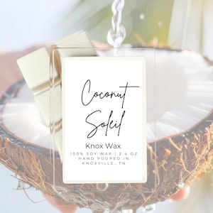 May include: A clear rectangular label with the words "Coconut Soleil" in script font, over a halved coconut. The label also reads "Knox Wax" and "100% SOY WAX | 2.4 OZ HAND POURED IN KNOXVILLE, TN". Water pours over the coconut.