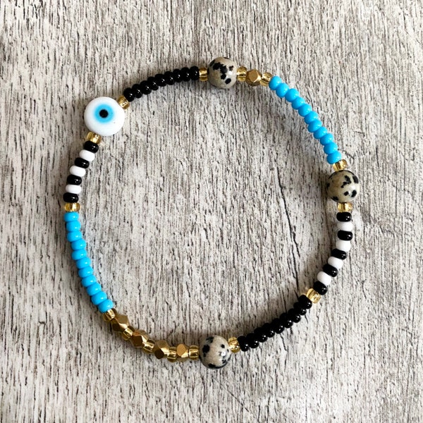 Black, turquoise and gold beaded bracelet with evil eye and Dalmatian Jasper beads. Handmade.