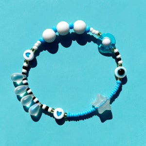 Sensory fidget bracelet. Sliding glow in the dark star, rolling bead, rubber, glass, evil eye. Turquoise.