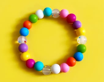 Pulsera sensorial de cuentas de silicona para aliviar la ansiedad, el TDAH y el autismo. Cuentas de colores arcoíris en cordón elástico.