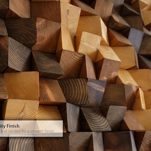 May include: A wall art piece made of wooden blocks in various shades of brown. The blocks are arranged in a geometric pattern, creating a textured and modern look. Each block is hand-sanded for a smooth finish. "High Quality Finish" is written in white text on a grey background at the bottom of the image.