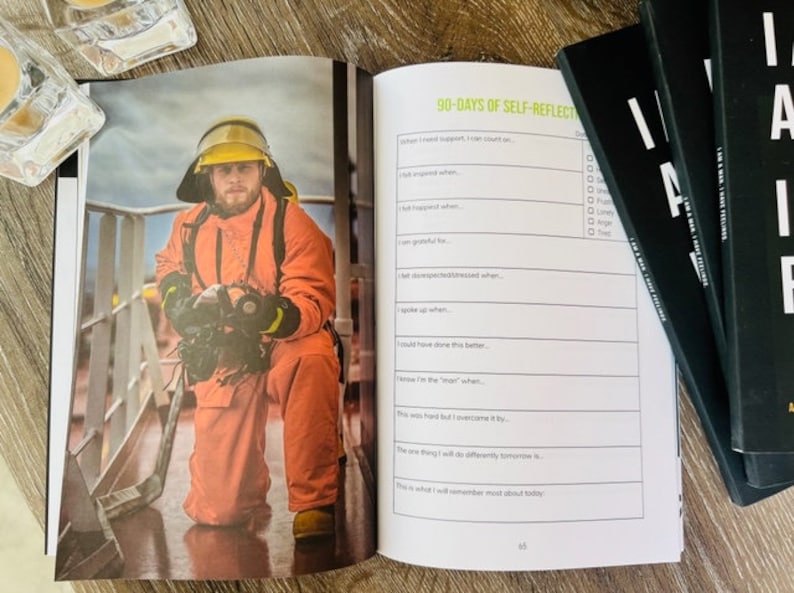 Pu&ograve; includere: Un vigile del fuoco con una tuta arancione e un casco giallo &egrave; inginocchiato su una piattaforma di metallo. Sta tenendo un tubo antincendio e guardando la telecamera. L'immagine &egrave; da un diario di auto-riflessione con il testo "90-Days of Self-Reflection" sulla pagina.