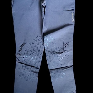 以下が含まれることがあります： 膝に幾何学模様、右足に「PS of Sweden」の文字が入ったダークグレーの乗馬用ズボンです。