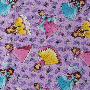 May include: A purple fabric featuring a repeating pattern of cartoon princesses in yellow, pink, and blue dresses. The princesses are depicted with brown hair, crowns, and wands, interspersed with small yellow butterflies and purple swirls.