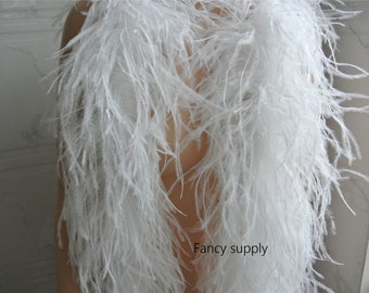 Puede incluir: Boa de plumas de avestruz blancas. La boa es larga y esponjosa, y es perfecta para añadir un toque de elegancia a cualquier atuendo.