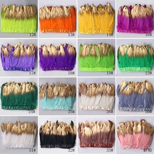 Puede incluir: Surtido de 36 adornos de plumas en varios colores, incluyendo rosa, azul, verde, morado, amarillo, naranja, rojo, blanco, negro y marrón. Cada adorno presenta plumas doradas y un respaldo de cinta.