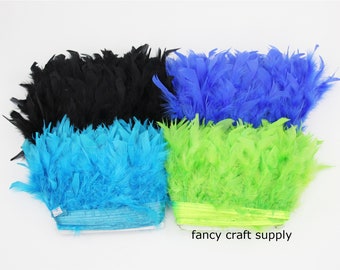 May include: Four spools of feather trim in black, blue, turquoise, and lime green. The spools are labeled "fancy craft supply".