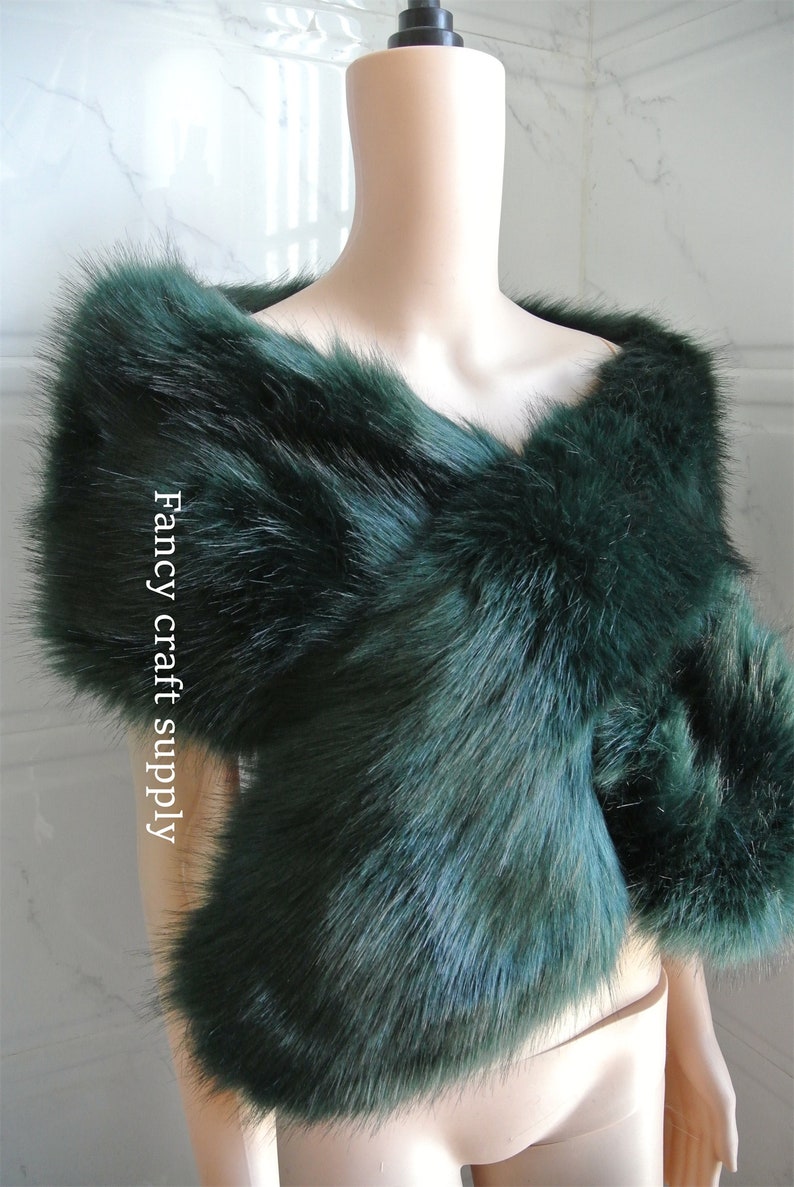May include: A dark green faux fur shawl. The shawl is draped over a mannequin's shoulders. The text "Fancy craft supply" is visible on the shawl.