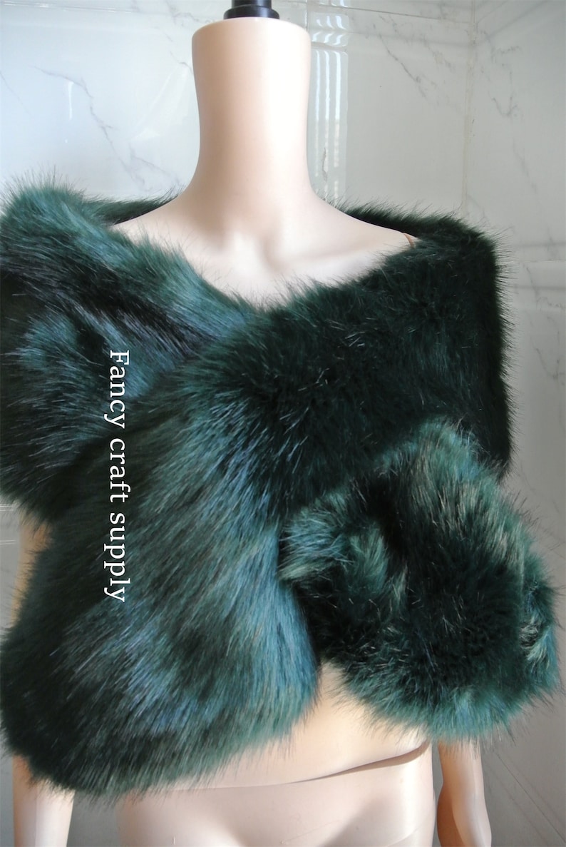 May include: A dark green faux fur shawl with a fluffy texture. The shawl is draped over a mannequin's shoulders. The text "Fancy craft supply" is visible on the shawl.