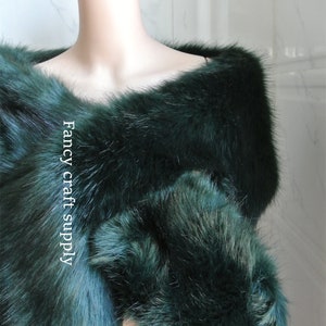 May include: A dark green faux fur shawl with a soft, fluffy texture. The shawl is draped over a mannequin's shoulders. The text "Fancy craft supply" is visible on the shawl.