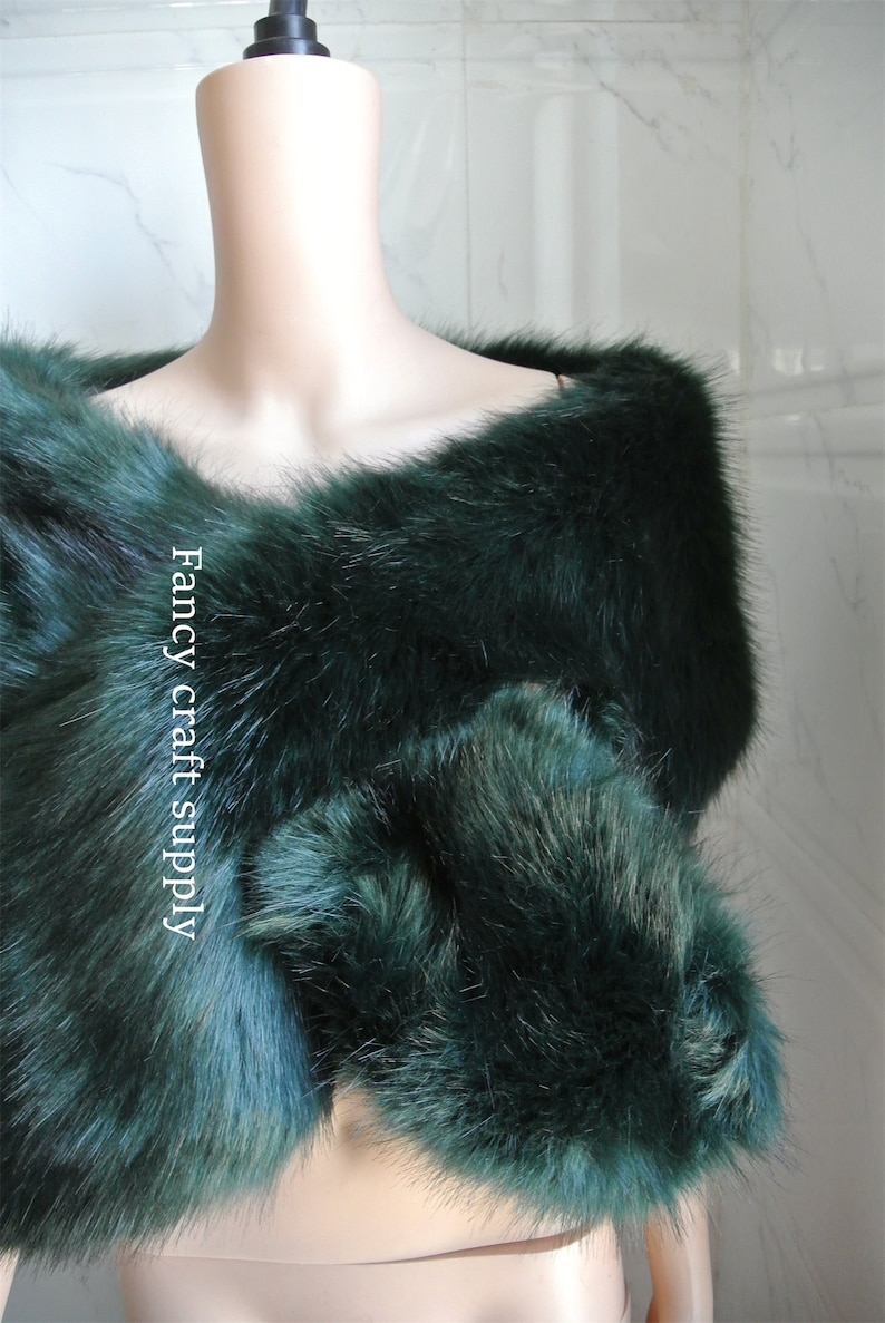 May include: A dark green faux fur shawl with a soft, fluffy texture. The shawl is draped over a mannequin's shoulders. The text "Fancy craft supply" is visible on the shawl.