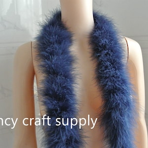 May include: A long, dark blue feather boa. The boa is draped around a mannequin's neck. The boa is soft and fluffy.