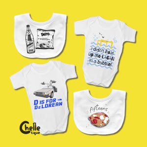 Peut inclure: Quatre bodies et bavoirs blancs pour bébés avec différents motifs. Un body présente un graphique de voiture DeLorean et le texte "D IS FOR DELOREAN". Un autre porte le texte "I didn't float up the LAGAN in a bubble!". Deux bavoirs présentent une bouteille de soda Maine et des chips Tayto, et un biscuit avec le mot "fifteens".