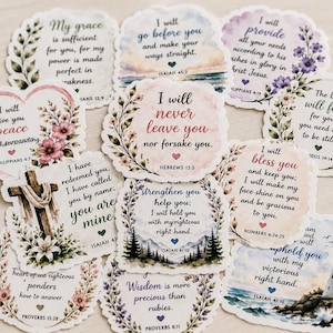 May include: A collection of eleven die-cut stickers featuring various Bible verses and inspirational quotes. Each sticker has a unique shape with floral, landscape, or cross illustrations, printed in colorful watercolor-style designs.