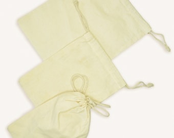 May include: Three off-white cotton drawstring bags. The bags are made of natural fabric and have a simple design.