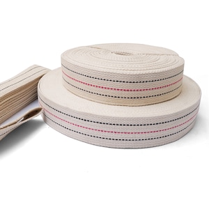 May include: Two rolls of natural cotton webbing with black and red stripes. The webbing is rolled up and stacked on top of each other.
