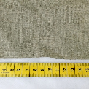 May include: A close-up of a beige fabric swatch with a yellow measuring tape. The tape reads "2, 3, 4, 5, 6, 7, 8, 9, 10, 11, 12, 13, 14, 15, 16, 17, 18, 19, 20" and "Made in Germany".