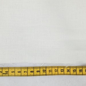 May include: A close-up of a white fabric with a textured weave. A yellow measuring tape is placed at the bottom of the image, showing measurements from 2 to 22 inches.