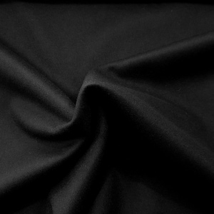 May include: Black fabric with a smooth, soft texture. The fabric is folded and draped, creating a subtle wave pattern.
